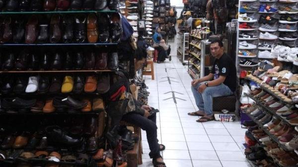 Pedagang menunggu pembeli di salah satu toko sepatu di kawasan pertokoan sepatu Cibaduyut, Jalan Cibaduyut Raya, Kota Bandung, Jawa Barat, Sabtu (25/5/2024).