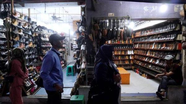 Pedagang menunggu pembeli di salah satu toko sepatu di kawasan pertokoan sepatu Cibaduyut, Jalan Cibaduyut Raya, Kota Bandung, Jawa Barat, Sabtu (25/5/2024).