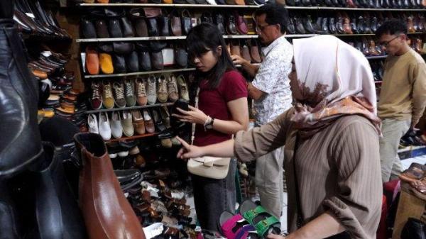 Pengunjung memilih sepatu yang dijual di salah satu toko sepatu di kawasan pertokoan sepatu Cibaduyut, Jalan Cibaduyut Raya, Kota Bandung, Jawa Barat, Sabtu (25/5/2024).