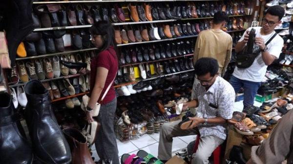 Pengunjung memilih sepatu yang dijual di salah satu toko sepatu di kawasan pertokoan sepatu Cibaduyut, Jalan Cibaduyut Raya, Kota Bandung, Jawa Barat, Sabtu (25/5/2024).