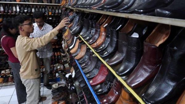 Pengunjung memilih sepatu yang dijual di salah satu toko sepatu di kawasan pertokoan sepatu Cibaduyut, Jalan Cibaduyut Raya, Kota Bandung, Jawa Barat, Sabtu (25/5/2024).