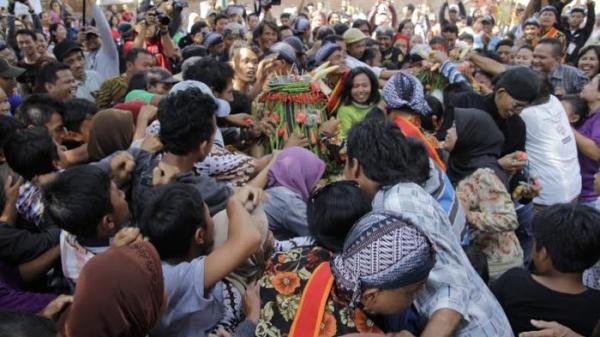 Warga berebut gunungan di halaman depan Masjid Besar Mataram, Kotagede, Minggu (18/5/2014). Sebelum diadakannya acara Nawu Sendang Selirang, diadakan kirab budaya Ambengan Agung yang mengkirab peralatan yang digunakan untuk nawu dan gunungan yang berisi beragam sayuran dan makanan.