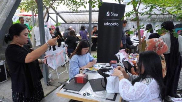 Tokopedia, Antonia Adega (kanan) bersama sejumlah jurnalis mengikuti workshop menghias tas dari bahan kain banner bekas di halaman Kozi Coffee, Jalan Dipatiukur, Kota Bandung, Jawa Barat, Kamis (13/6/2024).