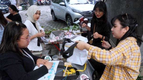 Sejumlah jurnalis mengikuti workshop menghias tas dari bahan kain banner bekas di halaman Kozi Coffee, Jalan Dipatiukur, Kota Bandung, Jawa Barat, Kamis (13/6/2024).