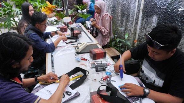 Sejumlah jurnalis mengikuti workshop menghias tas dari bahan kain banner bekas di halaman Kozi Coffee, Jalan Dipatiukur, Kota Bandung, Jawa Barat, Kamis (13/6/2024).