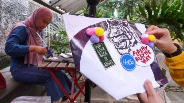 Sejumlah jurnalis mengikuti workshop menghias tas dari bahan kain banner bekas di halaman Kozi Coffee, Jalan Dipatiukur, Kota Bandung, Jawa Barat, Kamis (13/6/2024).