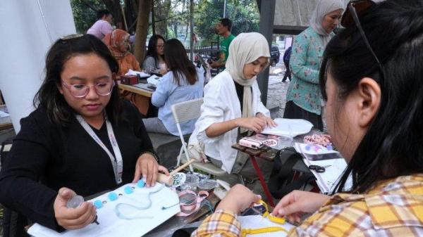 Sejumlah jurnalis mengikuti workshop menghias tas dari bahan kain banner bekas di halaman Kozi Coffee, Jalan Dipatiukur, Kota Bandung, Jawa Barat, Kamis (13/6/2024).