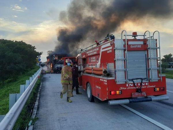 Petugas pemadam kebakaran berusaha memadamkan api yang melahap bus PO Pahala Kencana di ruas tol Jombang-Mojokerto