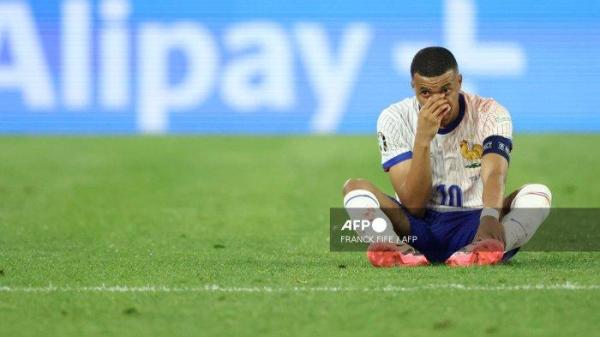 Penyerang Prancis #10 Kylian Mbappe duduk di foto setelah cedera selama pertandingan sepak bola Grup D UEFA Euro 2024 antara Austria dan Prancis di Duesseldorf Arena di Duesseldorf pada 17 Juni 2024. (Foto oleh FRANCK FIFE / AFP)