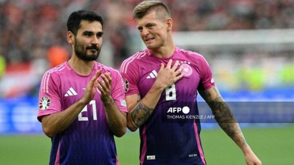 Gelandang Jerman #08 Toni Kroos berbicara dengan gelandang Jerman #21 Ilkay Gundogan setelah pertandingan sepak bola Grup A UEFA Euro 2024 antara Jerman dan Hongaria di Stuttgart Arena di Stuttgart pada 19 Juni 2024. (Foto oleh THOMAS KIENZLE / AFP)