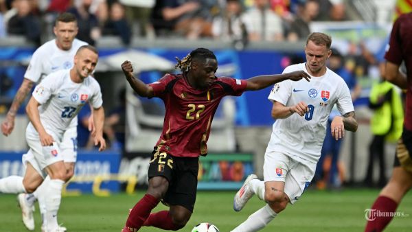 Penyerang Belgia #22 Jeremy Doku ditandai oleh gelandang Slovakia #08 Ondrej Duda selama pertandingan sepak bola Grup E UEFA Euro 2024 antara Belgia dan Slovakia di Frankfurt Arena di Frankfurt am Main pada 17 Juni 2024. (Photo by THOMAS KIENZLE / AFP)