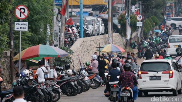 Sejumlah kendaraan terparkir di tepi jalan kawasan Pamulang, Tangsel. Meski rambu dilarang parkir sudah terpasang, area itu masih saja jadi lokasi parkir liar.