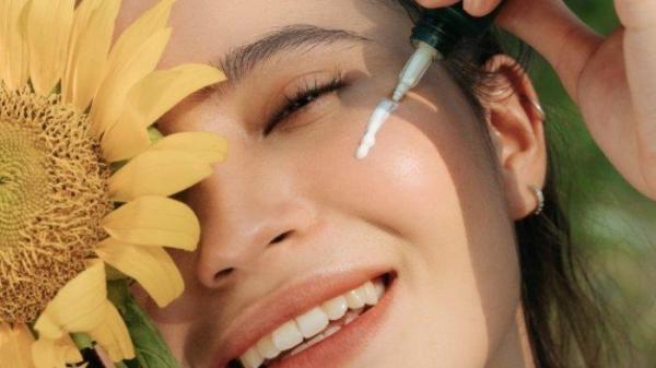Ilustrasi seorang wanita yang mengaplikasikan produk sunscreen dengan SPF yang tinggi agar kulit tetap sehat dan terlindungi.