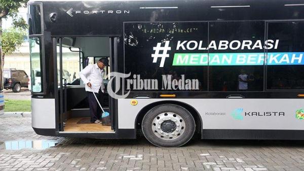 Petugas menyapu bagian dalam bus listrik di Halte J City, Kota Medan, Rabu (1/5/2024). Pemko Medan melalui Dishub Medan mengoperasikan empat unit bus listrik gratis dengan 38 titik halte untuk mewujudkan transportasi umum yang ramah lingkungan di Kota Medan.