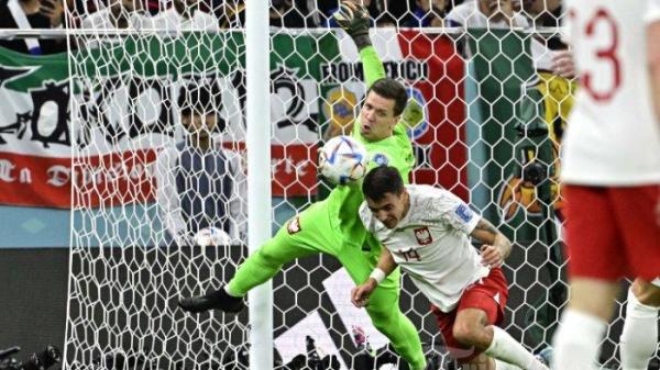 Kiper Polandia Wojciech Szczesny (kiri) meninju bola di depan bek Polandia Jakub Kiwior selama pertandingan sepak bola babak 16 besar Piala Dunia Qatar 2022 antara Prancis dan Polandia di Stadion Al-Thumama di Doha pada 4 Desember 2022.