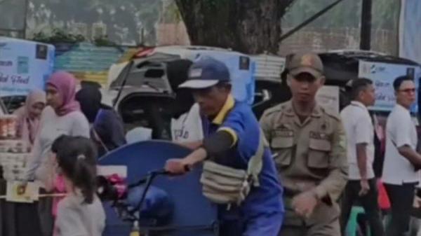 Seorang Satpol PP Medan dan Pedagang Roti yang sudah tua saat diterbitkan dengan cara mendorong sepedanya hingga hampir jatuh viral di sosial media, Senin (22/7/2024).