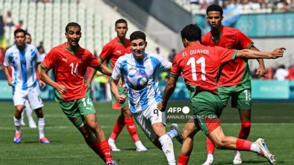 Gelandang Maroko #14 Oussama Targhalline, penyerang Argentina #09 Julian Alvarez, bek Maroko #11 Zakaria El Ouahdi, dan gelandang Maroko #18 Amir Richardson berebut bola dalam pertandingan sepak bola Grup B putra antara Argentina dan Maroko selama Olimpiade Paris 2024 di Stadion Geoffroy-Guichard di Saint-Etienne pada 24 Juli 2024. <div class=