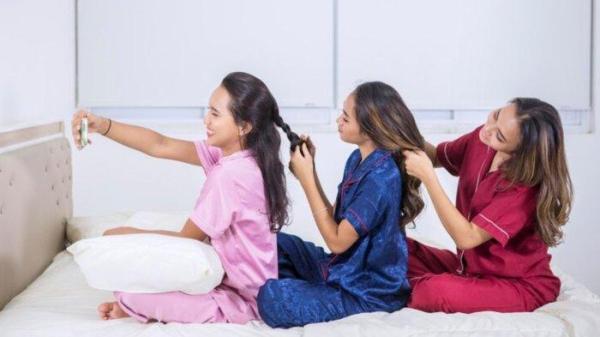 Girls tying hair to each other and selfie photo