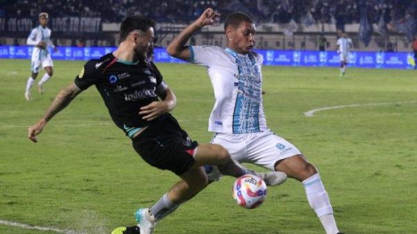 Gelandang tengah Persib Bandung, Marc Klok menendang bola ke arah gawang dihadang gelandang bertahan PSBS Biak, Jonata Felipe pada laga perdana Liga 1 2024-2025 di Stadion Si Jalak Harupat, Kabupaten Bandung, Jawa Barat, Jumat (9/8/2024).