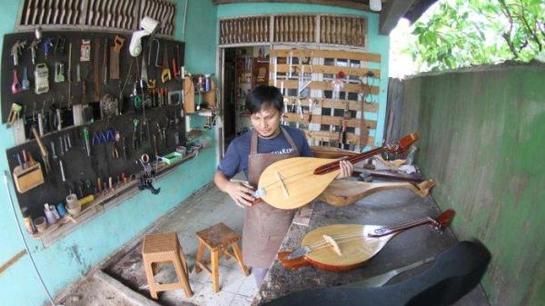 Pengrajin alat musik gambus Melayu, Robithah Irawan (34) tengah bekerja di workshop nya Jalan Kartama Pekanbaru, Jumat (9/8/2024).
