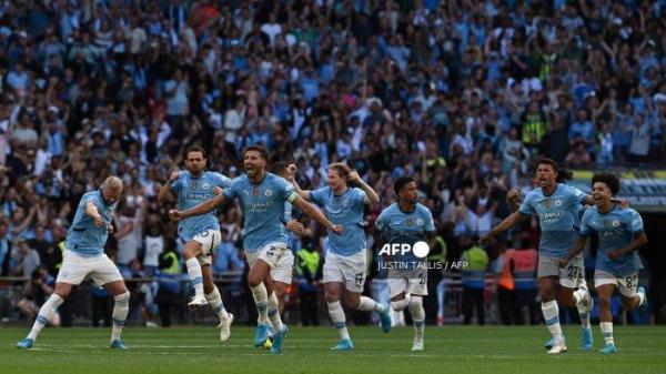 Bek Manchester City asal Portugal #03 Ruben Dias dan rekan setimnya merayakan gol kemenangan setelah bek Manchester City asal Swiss #25 Manuel Akanji mencetak gol kemenangan dalam adu penalti dalam pertandingan Community Shield antara Manchester City dan Manchester United di Stadion Wembley, London pada 10 Agustus 2024. (Foto oleh JUSTIN TALLIS / AFP)