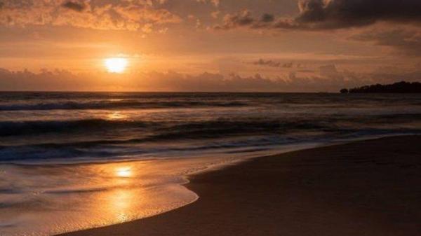 Suasana Pantai Ciantir Sawarna saat momen sunset.