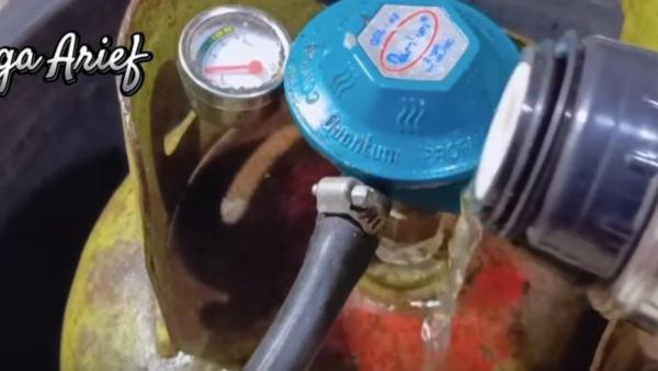 Air hangat disiramkan ke tabung gas agar bisa menyala lagi.