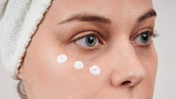 Ilustrasi wanita menggunakan eye cream.