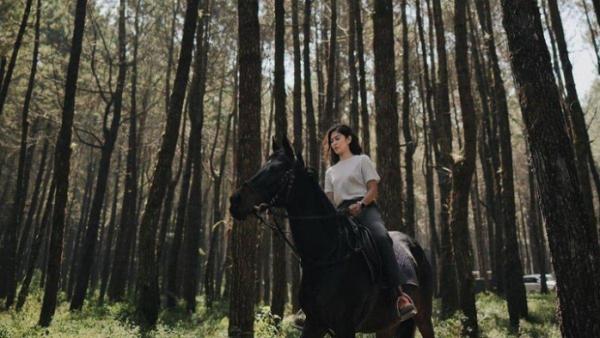 Pesona Dian Sastro saat berkuda di tengah hutan pinus