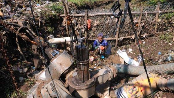 Petugas Polder Cipalasari 1, Nana Suntana (40) membersihkan sampah yang nyangkut dan menyumbat di pompa pengendali banjir Polder Cipalasari 1, Kampung Citeureup, Desa/Kecamatan Dayeuhkolot, Kabupaten Bandung, Jawa Barat, Kamis (12/9/2024).