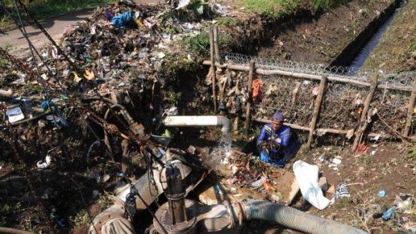 Petugas Polder Cipalasari 1, Nana Suntana (40) membersihkan sampah yang nyangkut dan menyumbat di pompa pengendali banjir Polder Cipalasari 1, Kampung Citeureup, Desa/Kecamatan Dayeuhkolot, Kabupaten Bandung, Jawa Barat, Kamis (12/9/2024).