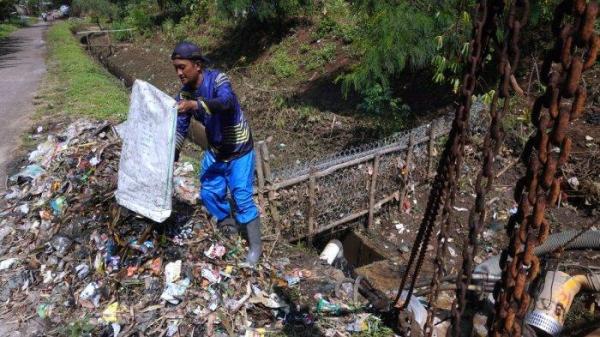 Petugas Polder Cipalasari 1, Nana Suntana (40) mengumpulkan sampah yang nyangkut dan menyumbat di pompa pengendali banjir Polder Cipalasari 1, Kampung Citeureup, Desa/Kecamatan Dayeuhkolot, Kabupaten Bandung, Jawa Barat, Kamis (12/9/2024).