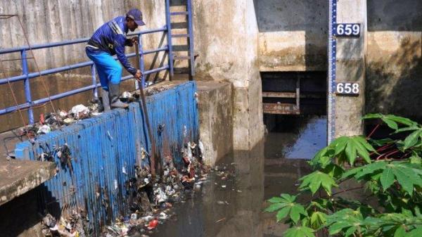 Petugas Polder Cipalasari 1, Nana Suntana (40) membersihkan sampah yang nyangkut dan menyumbat di besi penyaringan kolam penampungan air pengendali banjir Polder Cipalasari 1, Kampung Citeureup, Desa/Kecamatan Dayeuhkolot, Kabupaten Bandung, Jawa Barat, Kamis (12/9/2024).