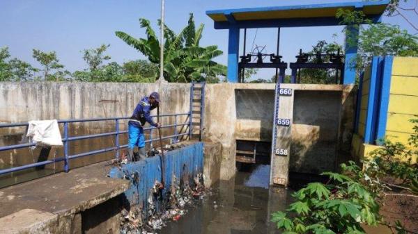 Petugas Polder Cipalasari 1, Nana Suntana (40) membersihkan sampah yang nyangkut dan menyumbat di besi penyaringan kolam penampungan air pengendali banjir Polder Cipalasari 1, Kampung Citeureup, Desa/Kecamatan Dayeuhkolot, Kabupaten Bandung, Jawa Barat, Kamis (12/9/2024).