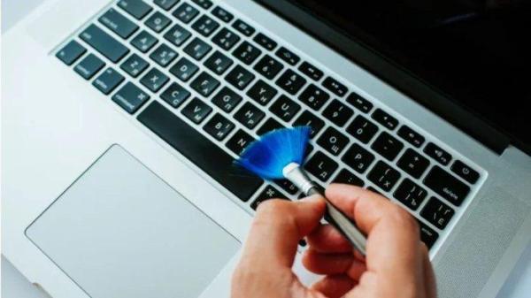 Ilustrasi membersihkan keyboard laptop dengan kuas yang halus