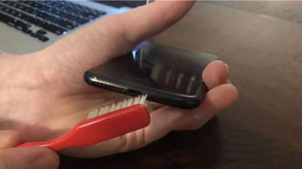 Ilustrasi membersihkan lubang charger HP