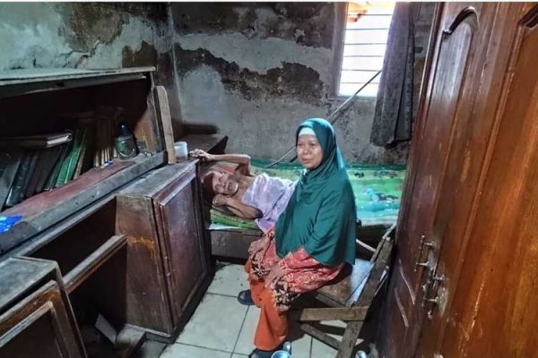 Dasini, istri Carli, menunjukan kondisi kesehatan Carli yang sudah terbaring di kasurnya di Desa Benda, Kecamatan Karangampel Kabupaten Indramayu, pada Rabu (9/10/2024) siang.