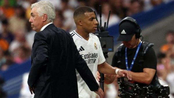 Penyerang Real Madrid Kylian Mbappe berjalan melewati pelatih asal Italia Carlo Ancelotti (kiri) saat meninggalkan lapangan selama pertandingan liga Spanyol antara Real Madrid dan Real Valladolid di stadion Santiago Bernabeu pada tanggal 25 Agustus 2024.
