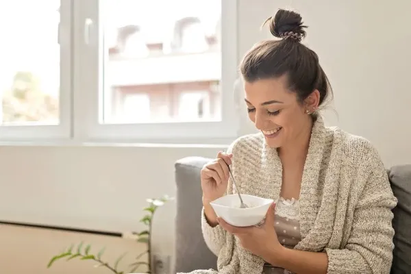 Young woman eating an oatmeal in the morning . <div class=