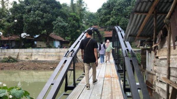 Salah seorang warga terlihat melintas di atas jembatan besi yang dibangun oleh keluarga Sunardi, Selasa (19/11/2024). Sunardi membangun jembatan ini setelah akses jalan menuju dan dari rumahnya ditutup oleh tetangganya.

TRIBUNJATENG/TITO ISNA UTAMA