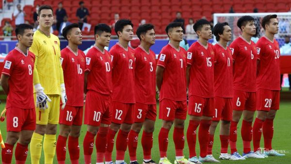 Para pemain Vietnam berdiri sambil menyanyikan lagu kebangsaannya sebelum dimulainya pertandingan sepak bola Grup D Piala Asia AFC Qatar 2023 antara Jepang dan Vietnam di Stadion Al-Thumama di Doha. Minggu (14 Januari 2024). (KARIM JAAFAR / AFP)
