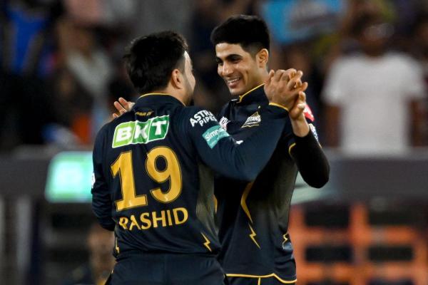 Gujarat Titans’ Rashid Khan (L) celebrates with captain Shubman Gill after taking the wicket of Punjab Kings’ Jitesh Sharma. 