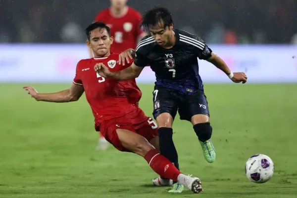 JAKARTA, INDONESIA - NOVEMBER 15: Kaoru Mitoma of Japan is tackled by Rizky Ridho Ramadhani of Indonesia in the first half during the FIFA World Cup Asian 3rd Qualifier Group C match at Gelora Bung Karno Stadium on November 15, 2024 in Jakarta, Indonesia. (Photo by Robertus Pudyanto/Getty Images)