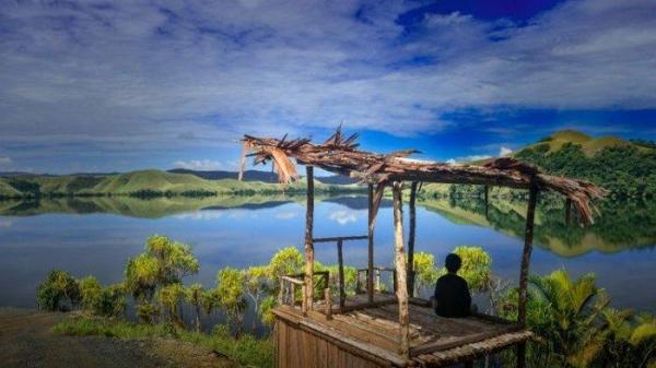 Salah satu warga, saat duduk di sebuah bukit sambil memandang ke arah Danau Sentani di Tanjung Cinta, Kampung Doyo Lama, Distrik Waibu, Kabupaten Jayapura, Papua.