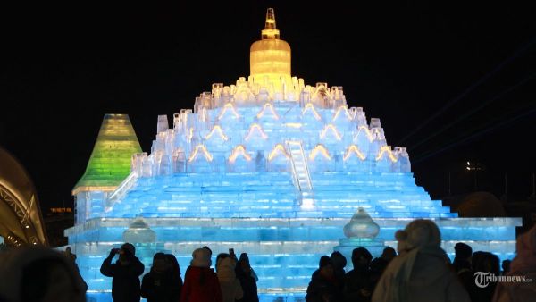 Foto yang diambil pada 21 Desember 2024 ini menunjukkan orang-orang yang mengunjungi Festival Dunia Es dan Salju Harbin di Harbin, provinsi Heilongjiang, Tiongkok timur laut. - Festival tahunan edisi ke-26 secara resmi dibuka pada tanggal 21 Desember di Harbin, yang juga dikenal sebagai 