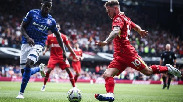 Gelandang Liverpool Alexis Mac Allister (Kanan) menendang bola melewati bek Ipswich Town Axel Tuanzebe selama pertandingan sepak bola Liga Primer Inggris antara Ipswich Town dan Liverpool di Portman Road di Ipswich, Inggris timur pada 17 Agustus 2024.