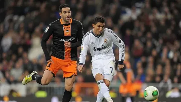 MADRID, SPAIN - JANUARY 15: Cristiano Ronaldo (R) of Real Madrid CF shoots at goal beside Adil Rami of Valencia CF during the Copa del Rey Quarter Final, 1st leg match between Real Madrid CF and Valencia CF at Estadio Santiago Bernabeu on January 15, 2013 in Madrid, Spain. (Photo by Denis Doyle/Getty Images)