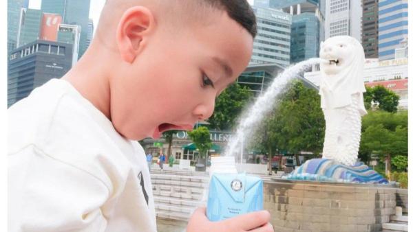 Dalam unggahan yang lain, Rayyanza tampak bergaya eperti sedang mengisi botol minuman menggunakan air yang mengalir dari patung tersebut.