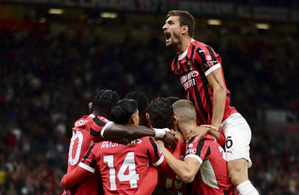 Pemain AC Milan, Theo Hernandez, merayakan gol pertama mereka bersama Matteo Gabbia dan rekan setimnya pada pertandingan Serie A antara AC Milan melawan Venezia di Stadion San Siro, Milan, Italia, Sabtu (14/9/2024). Foto: Daniele Mascolo/REUTERS 
