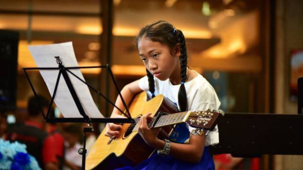 Anak perempuan sedang bermain gitar/kumparan. <div class=